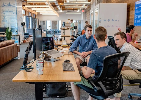 three guys talking at a office