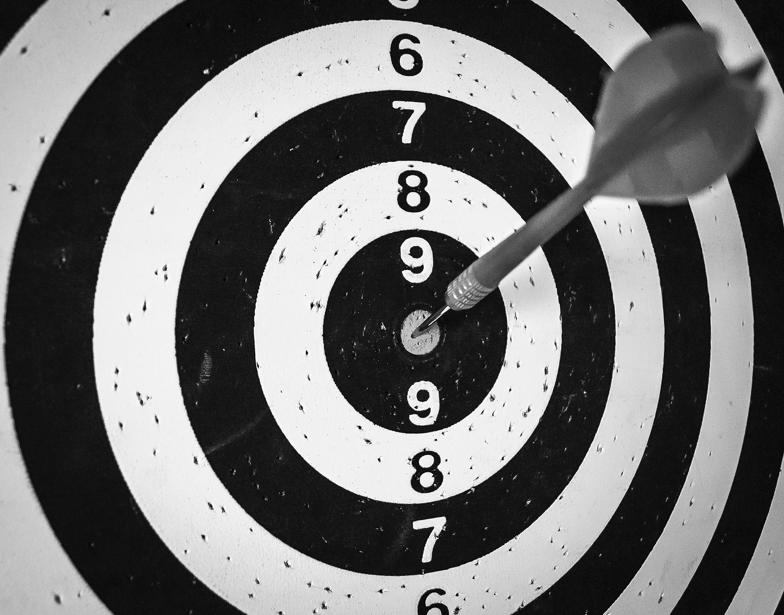 grey dart in the middle of the black and white dartboard